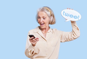 Senior woman in casuals using social media on her Smartphone against blue background