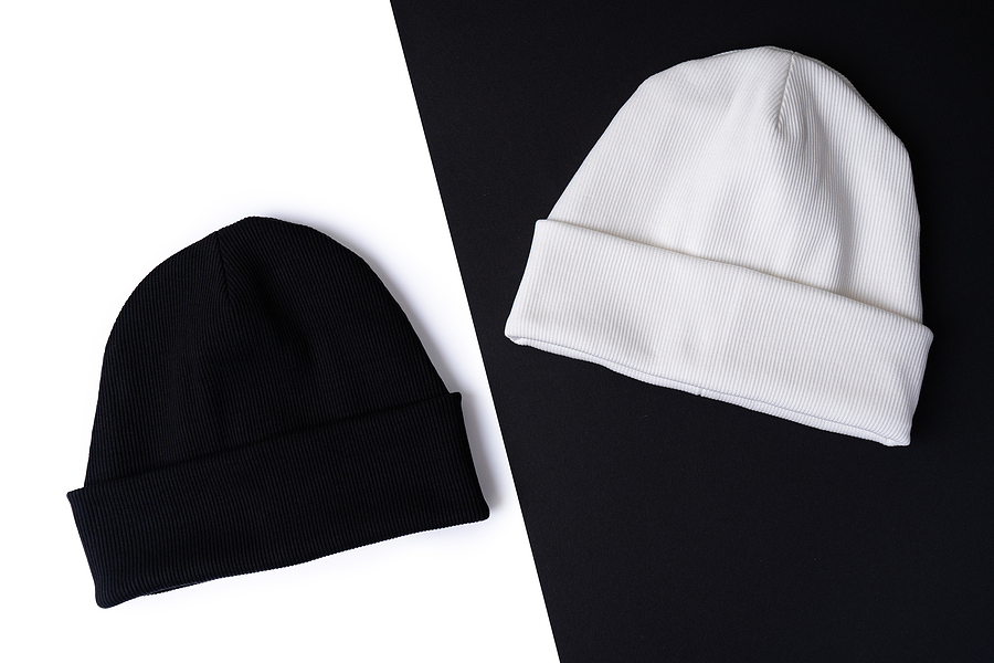 A black beanie on a white background and a white beanie on a black background.