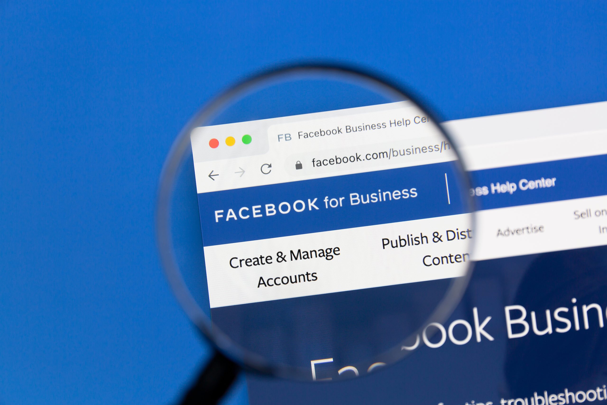 magnifying glass hovers over computer screen showing Facebook for Business webpage