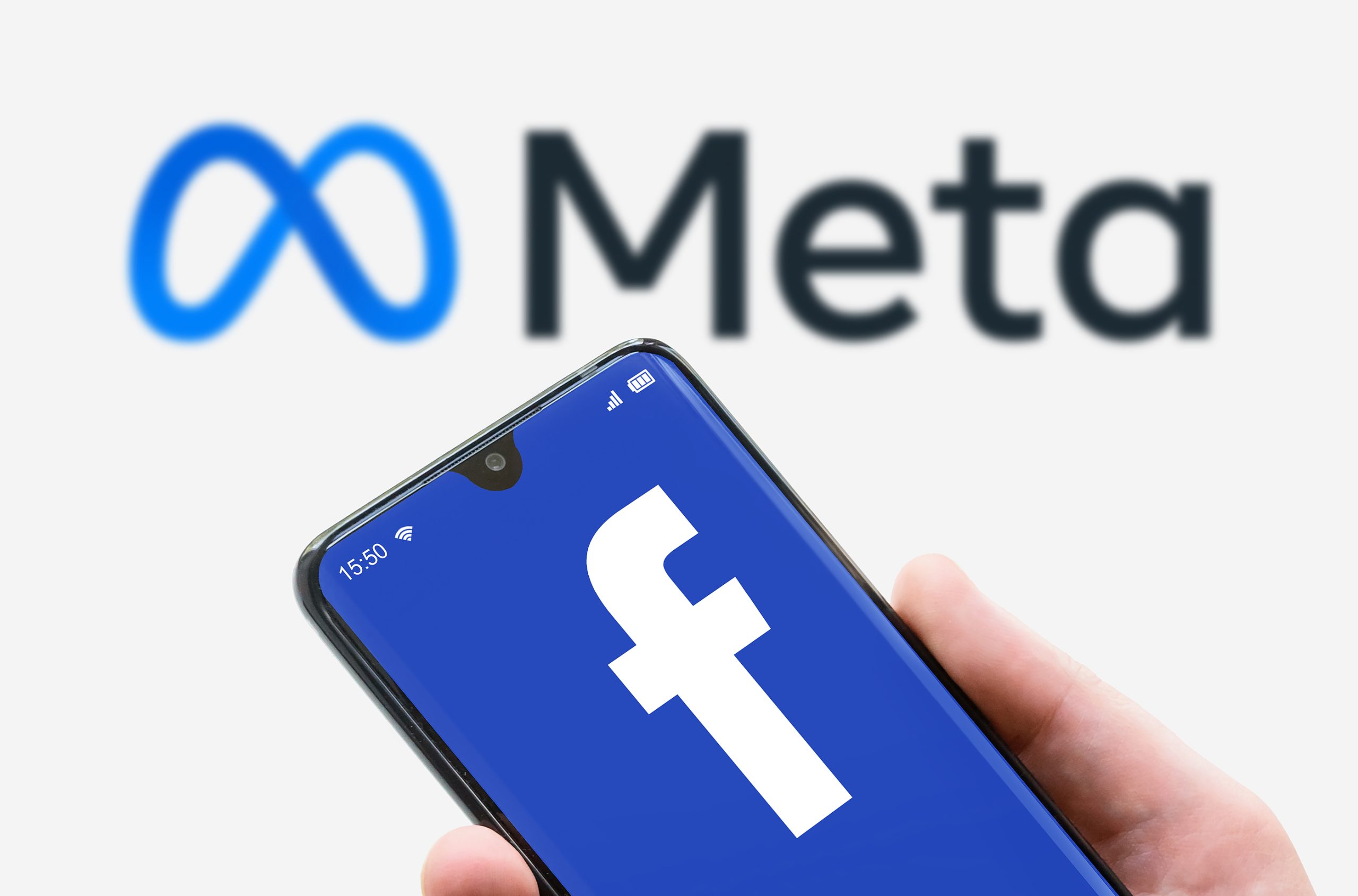 Smartphone displaying Facebook logo in front of a Meta logo. Meta is the parent company of Facebook and Instagram.